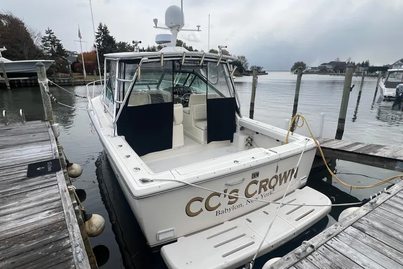 Slide: The Image of 1993 Tiara Yachts 3100 Open docked, rear view, overcast sky, marina setting. - 7