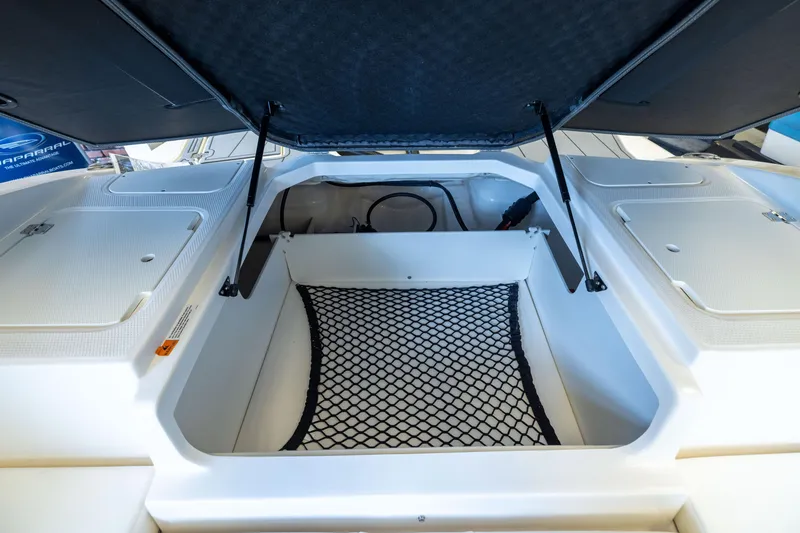 Slide: The Image of Open storage compartment in 2025 Chaparral 21 SSi OB boat, featuring a netted interior. - 23