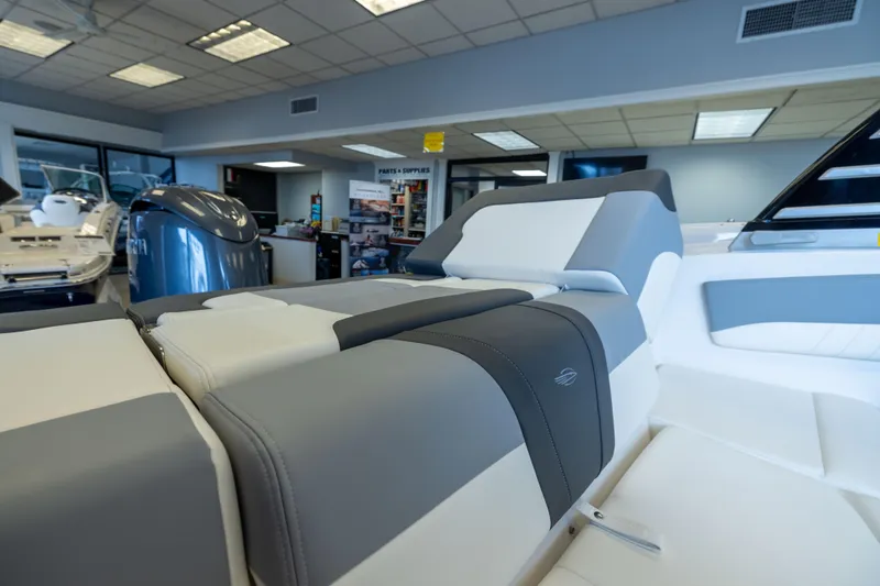 Slide: The Image of 2025 Chaparral 21 SSi OB boat interior with sleek gray and white seating in showroom. - 24