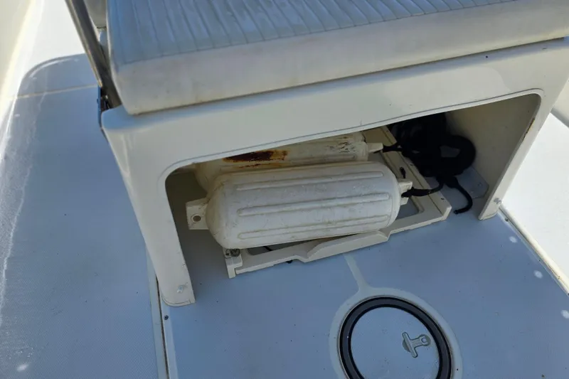 Slide: The Image of Storage compartment on a 2017 Boston Whaler 210 Montauk boat, featuring a white fender. - 13