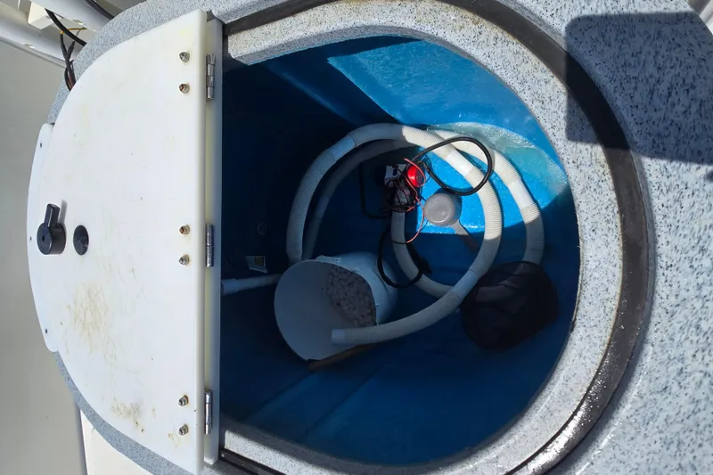 Slide: The Image of Livewell compartment in a 2017 Boston Whaler 210 Montauk boat, featuring hoses and wiring. - 20