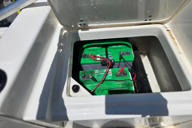 Slide: The Image of Battery compartment of a 2017 Boston Whaler 210 Montauk boat, featuring dual green batteries. - 27