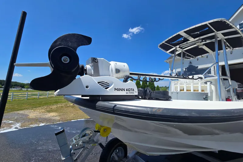 Slide: The Image of 2017 Boston Whaler 210 Montauk with Minn Kota Ulterra motor, parked outdoors under blue sky. - 32