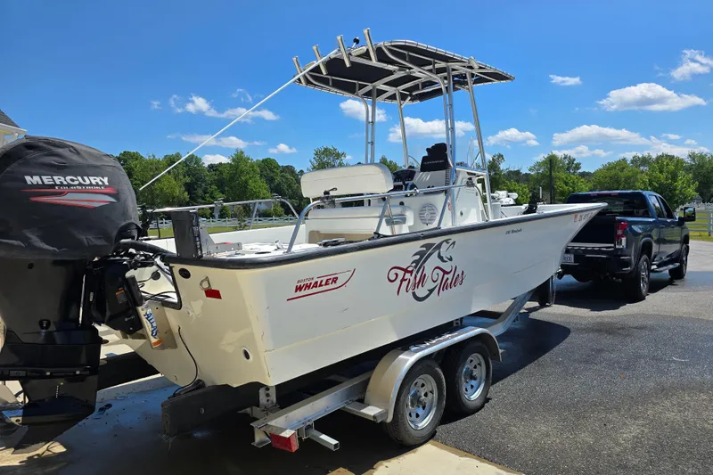 Slide: The Image of 2017 Boston Whaler 210 Montauk boat on trailer, featuring Mercury engine, sunny day. - 33