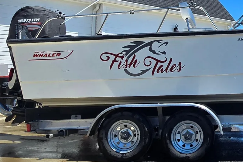Slide: The Image of 2017 Boston Whaler 210 Montauk boat on trailer with "Fish Tales" decal. - 6