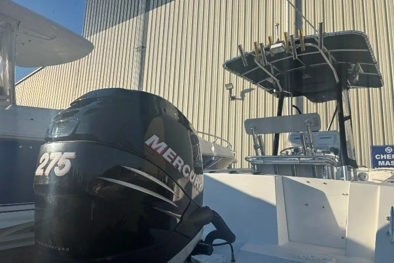 Slide: The Image of 1999 Contender 23 Open boat with Mercury 275 outboard engine, docked near a building. - 11