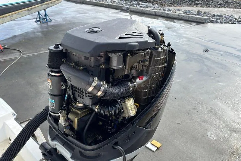 Slide: The Image of Outboard motor of a 1999 Contender 23 Open boat on a concrete surface. - 12