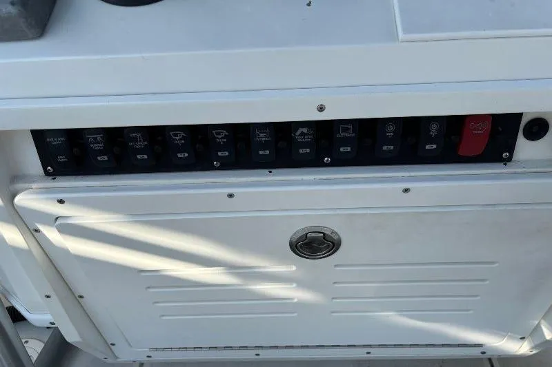 Slide: The Image of Control panel of a 1999 Contender 23 Open boat with labeled switches. - 19