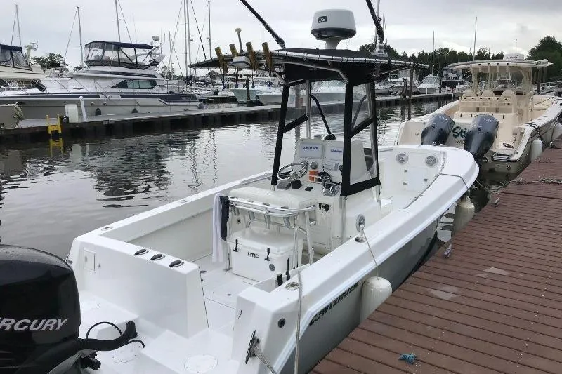 Slide: The Image of 1999 Contender 23 Open boat docked at marina with Mercury engine. - 2