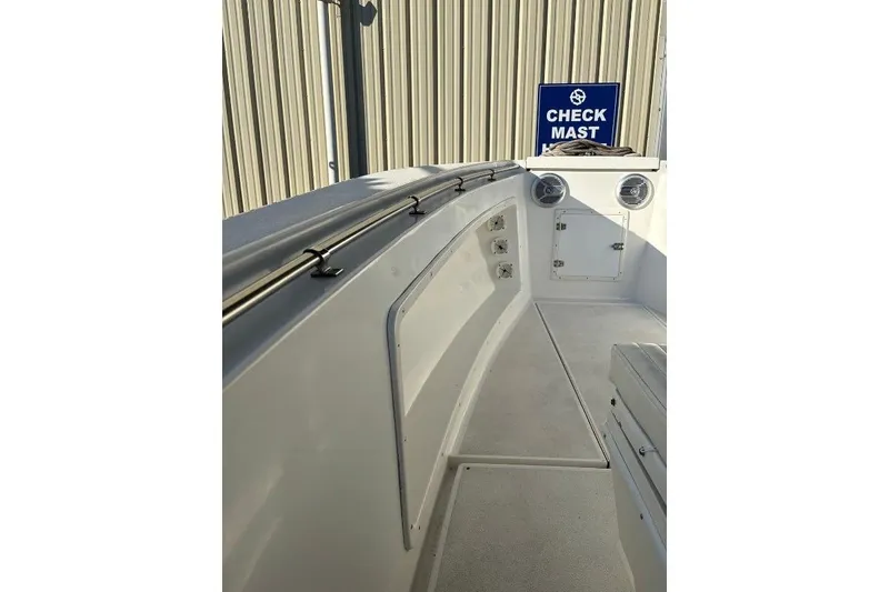 Slide: The Image of 1999 Contender 23 Open boat interior with seating and storage, featuring a "Check Mast" sign. - 20