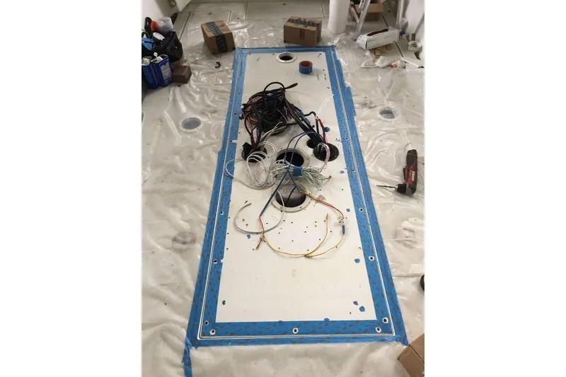 Slide: The Image of Interior view of a 1999 Contender 23 Open boat under maintenance, showing wiring and tools. - 22