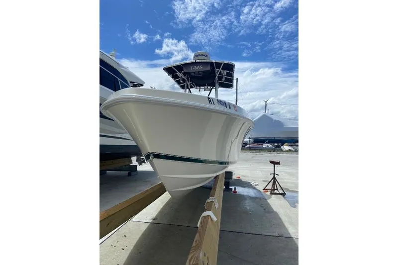Slide: The Image of 1999 Contender 23 Open boat on trailer under a clear blue sky. - 4