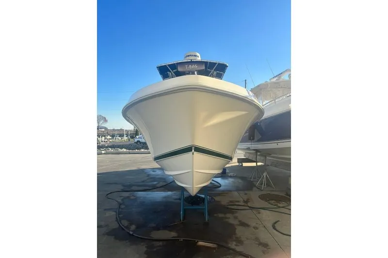Slide: The Image of 1999 Contender 23 Open boat on display, viewed from the front, under clear blue sky. - 5