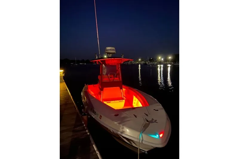 Slide: The Image of 1999 Contender 23 Open boat docked at night with vibrant red interior lighting. - 6