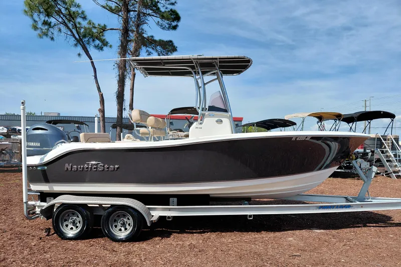 The Image of 2020 NauticStar 20 XS boat on trailer, displayed outdoors under clear sky. - 1