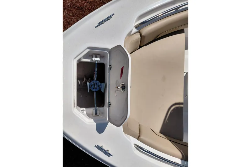 Slide: The Image of 2020 NauticStar 20 XS boat anchor compartment with open hatch and beige seating. - 11