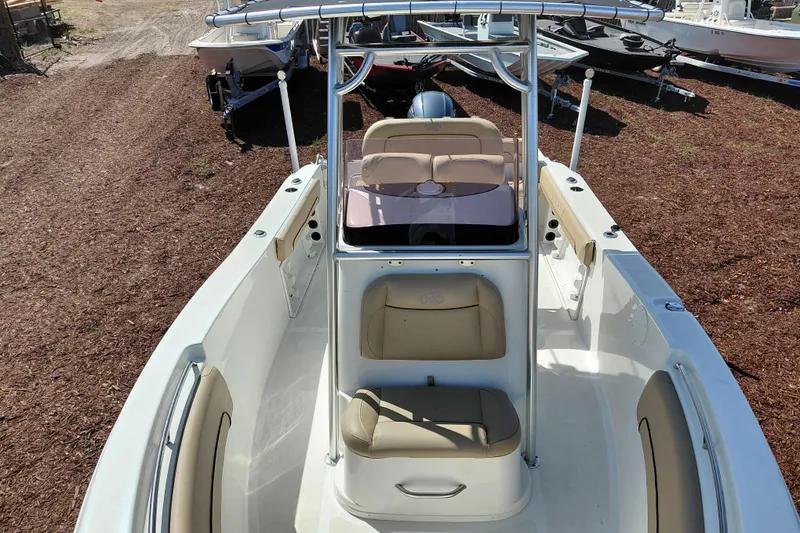 Slide: The Image of 2020 NauticStar 20 XS boat with beige seating and center console, parked on mulch. - 12