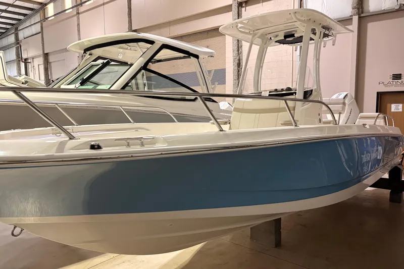 The Image of 2026 Boston Whaler 250 Dauntless boat in showroom, featuring sleek design and blue hull. - 0