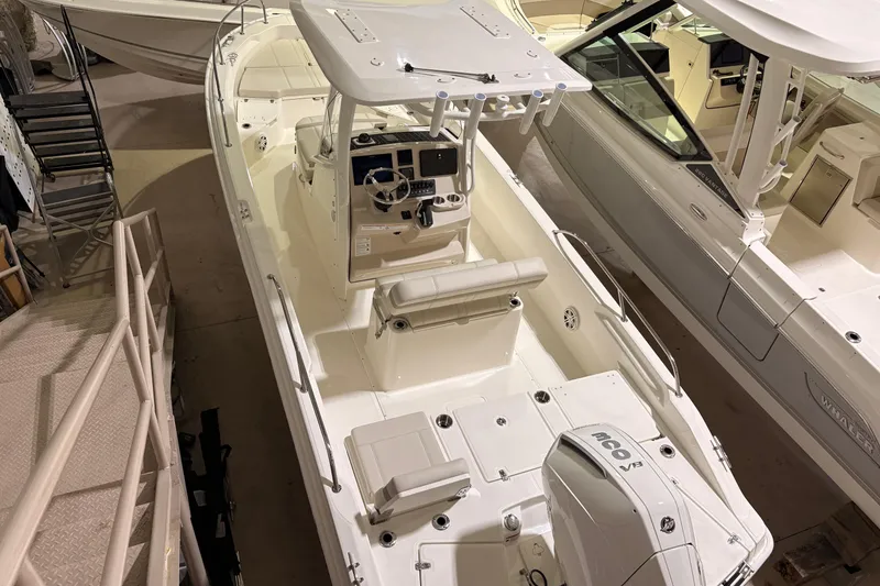 The Image of 2026 Boston Whaler 250 Dauntless boat in showroom, top view of sleek design and controls. - 1