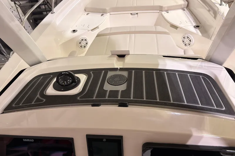 Slide: The Image of 2026 Boston Whaler 250 Dauntless dashboard with compass and speaker. - 13