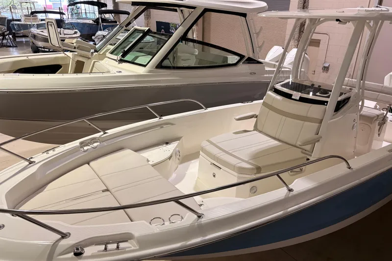 Slide: The Image of 2026 Boston Whaler 250 Dauntless boat displayed in showroom, featuring sleek design and spacious seating. - 3