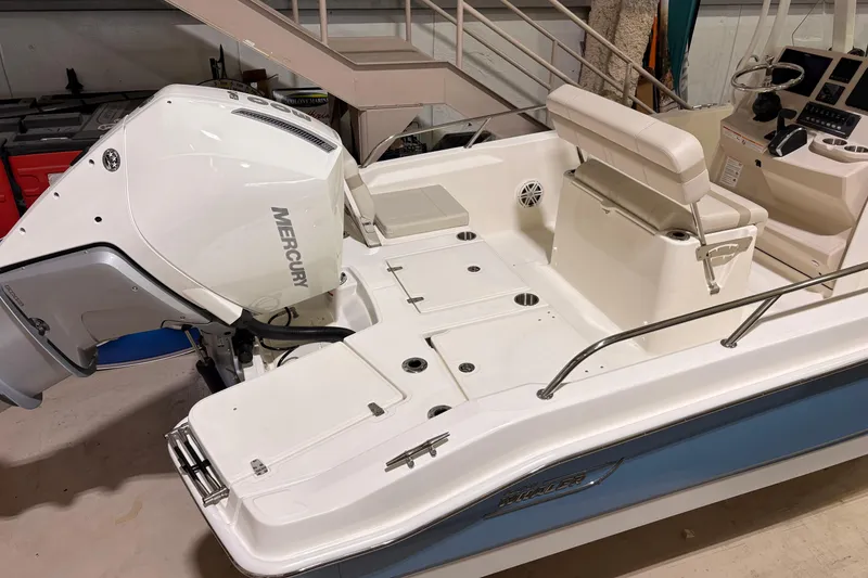 Slide: The Image of 2026 Boston Whaler 250 Dauntless boat with Mercury engine, interior view in a showroom. - 8