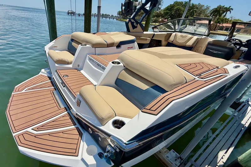 Slide: The Image of 2021 Nautique Super Air Nautique G21 boat with luxurious seating and teak deck on the water. - 10