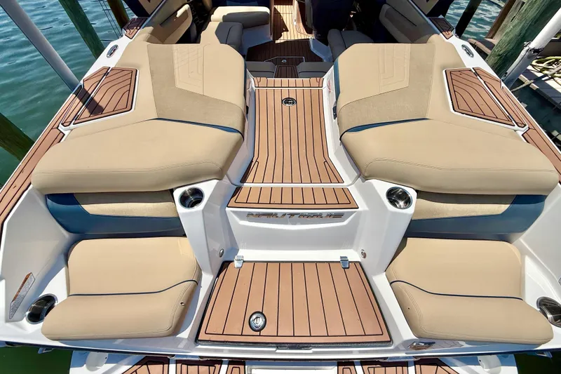 Slide: The Image of 2021 Nautique Super Air Nautique G21 boat interior with tan seating and teak flooring. - 11