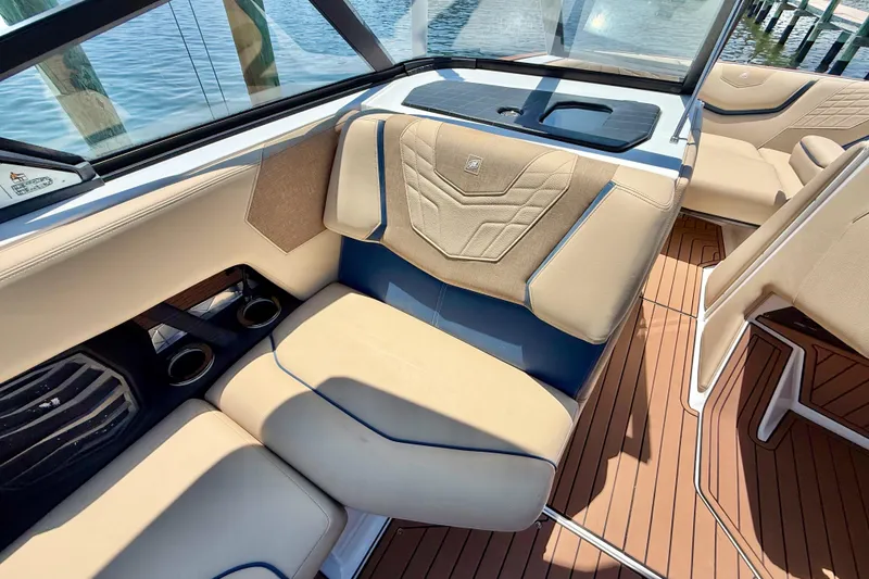Slide: The Image of 2021 Nautique Super Air Nautique G21 interior with beige seating and wood-style flooring. - 17