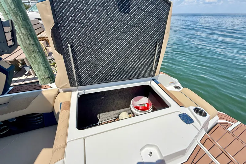 Slide: The Image of 2021 Nautique Super Air Nautique G21 boat storage compartment open by the water. - 19