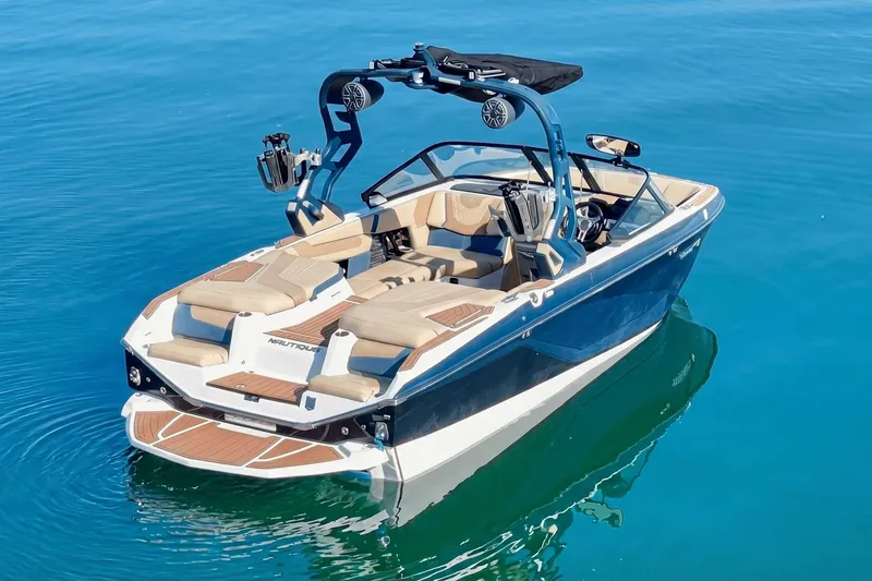 Slide: The Image of 2021 Nautique Super Air Nautique G21 boat on clear blue water. - 2