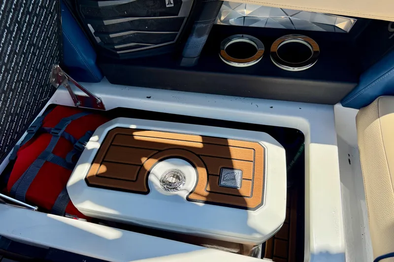 Slide: The Image of Storage compartment in 2021 Nautique Super Air Nautique G21 boat with cooler and life jacket. - 23