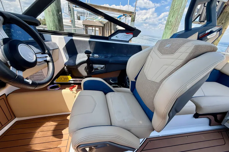 Slide: The Image of Interior of 2021 Nautique Super Air Nautique G21 boat with luxury seating and steering wheel. - 28