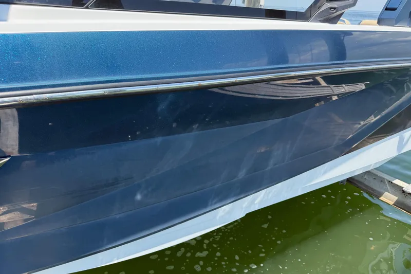 Slide: The Image of 2021 Nautique Super Air Nautique G21 boat hull in blue, docked on water. - 29