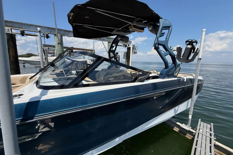 Slide: The Image of 2021 Nautique Super Air Nautique G21 boat docked, featuring sleek design and modern wakeboard tower. - 30
