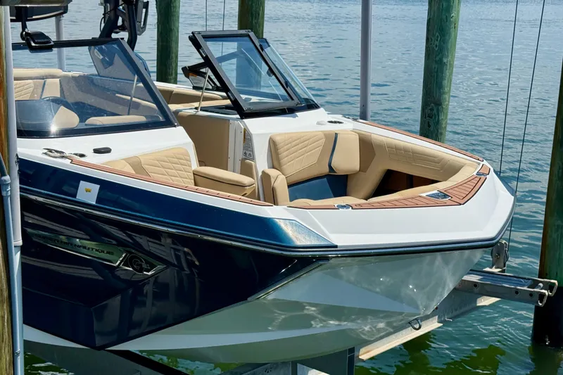 Slide: The Image of 2021 Nautique Super Air Nautique G21 boat docked on calm water. - 7