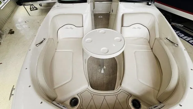 Slide: The Image of Interior of a 2012 Sea Ray 200 Sundeck with seating area and table. - 15