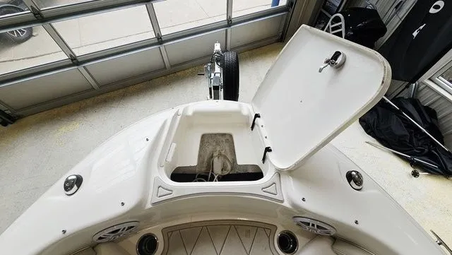 Slide: The Image of 2012 Sea Ray 200 Sundeck boat with open storage compartment indoors. - 18