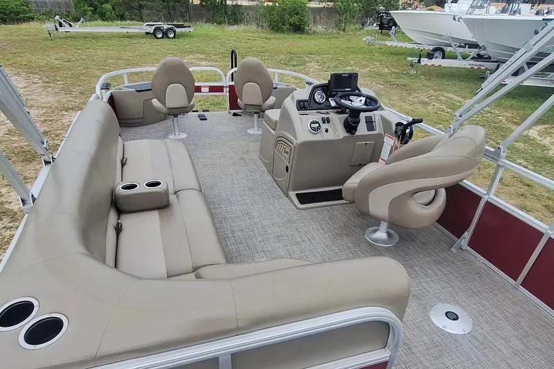 Slide: The Image of 2021 Ranger Reata 200F pontoon boat interior with beige seating and steering console. - 12