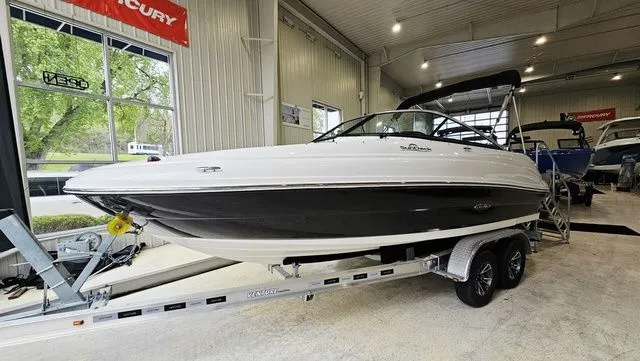 The Image of 2012 Sea Ray 200 Sundeck on trailer in a showroom. - 2