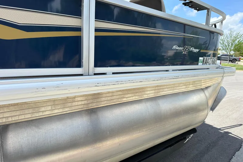 Slide: The Image of 2024 Sun Tracker Bass Buggy 16 XL Select pontoon boat, side view with blue and gold accents. - 13