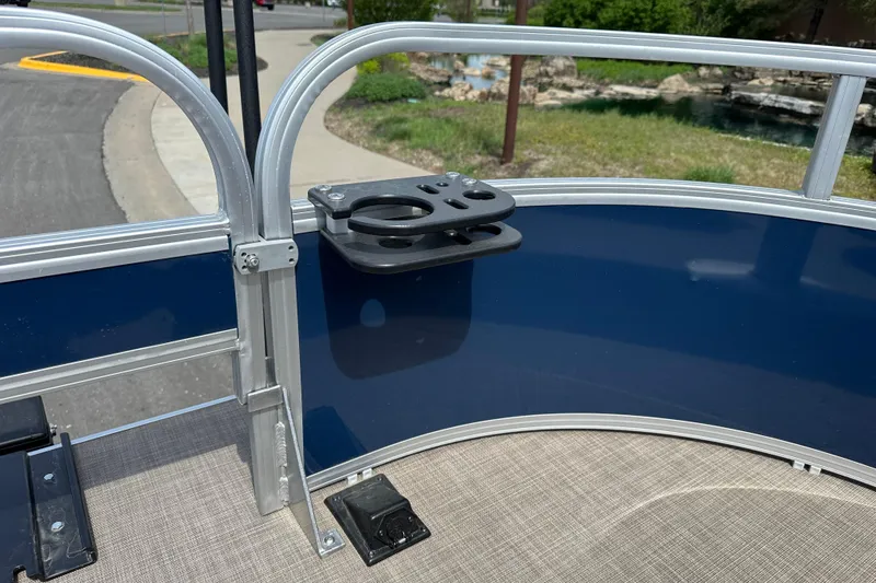 Slide: The Image of 2024 Sun Tracker Bass Buggy 16 XL Select boat railing with cup holder, outdoor setting. - 19