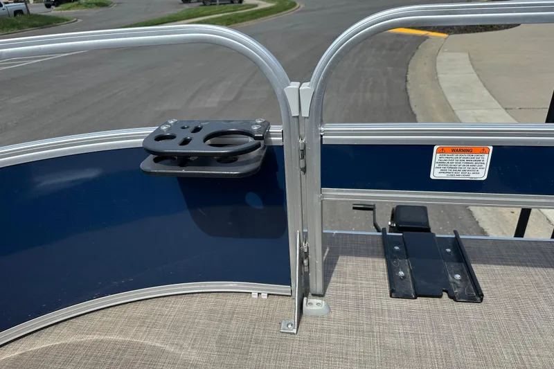 Slide: The Image of 2024 Sun Tracker Bass Buggy 16 XL Select boat railing with cup holder and warning label. - 20
