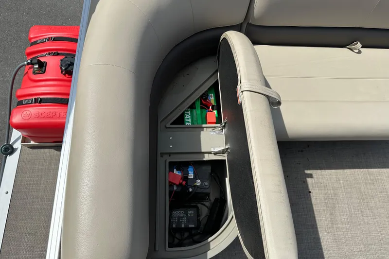 Slide: The Image of 2024 Sun Tracker Bass Buggy 16 XL Select boat storage compartment with red fuel tanks and battery. - 36