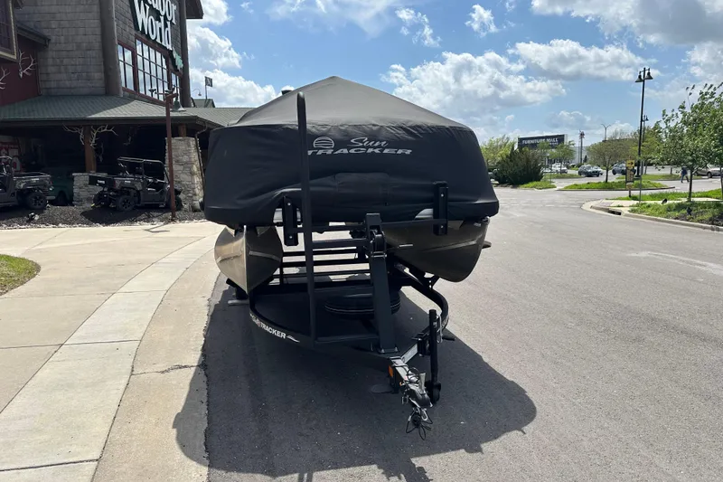 Slide: The Image of 2024 Sun Tracker Bass Buggy 16 XL Select covered on trailer, parked outside a store. - 4
