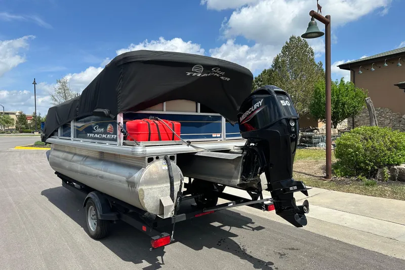 Slide: The Image of 2024 Sun Tracker Bass Buggy 16 XL Select pontoon boat with Mercury engine on trailer. - 6