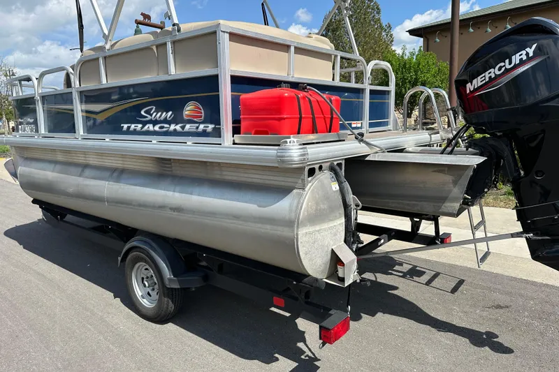 Slide: The Image of 2024 Sun Tracker Bass Buggy 16 XL Select pontoon boat on trailer with Mercury outboard motor. - 8
