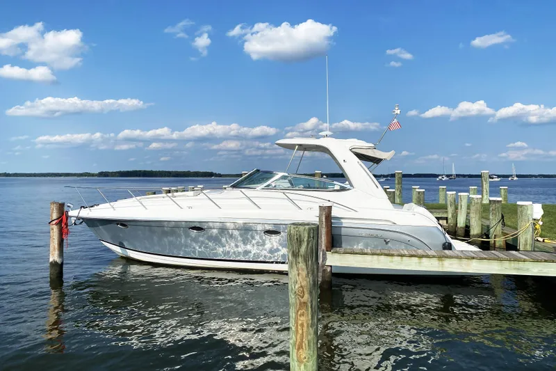 The Image of 2006 Formula 37 Performance Cruiser docked by a serene lake under a blue sky. - 0