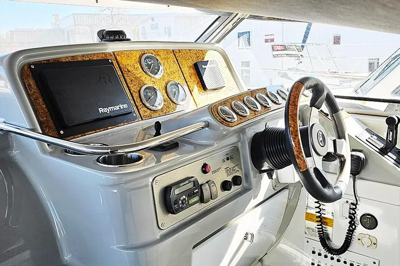 Slide: The Image of 2006 Formula 37 Performance Cruiser helm with Raymarine navigation and wood-accented steering wheel. - 22