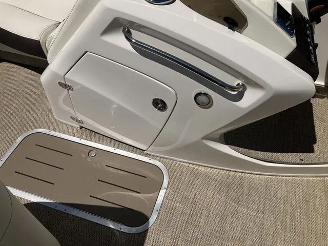 Slide: The Image of Interior of a 2019 Bennington 23 QLC boat with storage compartment and carpeted floor. - 22